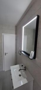 a white bathroom with a sink and a mirror at Smit apartman in Novi Vinodolski +16 photos