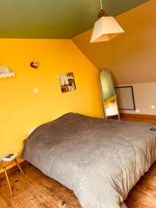a bedroom with a bed and a yellow wall at Gîte spacieux, Proche Plage, Grand jardin in Neufchâtel-Hardelot +30 photos