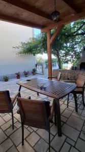 a wooden table and chairs on a patio at Smit apartman in Novi Vinodolski