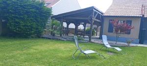 two chairs sitting in the grass in a yard at Gîte spacieux, Proche Plage, Grand jardin in Neufchâtel-Hardelot