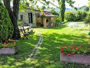 a garden with a table and benches and flowers at Holiday Home Il Lamone by Interhome in Ambra +30 photos