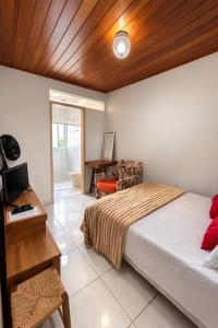 a bedroom with a bed and a desk and a chair at Pertinho do CENTRO - Hospedaria Vila Rica - Excelente Custo Benefício in Ouro Preto
