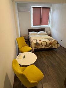 a room with a bed and two chairs and a table at Hotel Avanti in Zenica