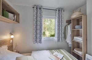 a bedroom with a bed and a window at Camping Bel Air - Cancale in Cancale