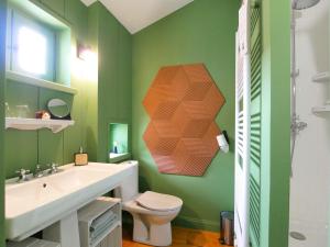 a green bathroom with a toilet and a sink at Maison Vitis in Fuissé +49 photos