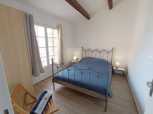 a bedroom with a bed with a blue comforter at Holiday Home Les Troenes by Interhome in Fréjus