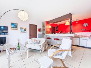 a living room with white furniture and a red wall at Holiday Home Gevanac by Interhome in Crozon