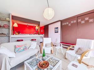 a living room with white furniture and red walls at Holiday Home Gevanac by Interhome in Crozon