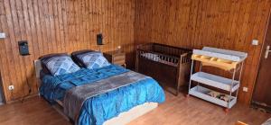 a bedroom with a bed and a wooden wall at gite climatisé jusqu'à 9 personnes secteurs la broque Obernai Strasbourg in La Broque