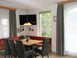 a dining room with a red couch and a table at Apartment Lechners Wohnwelt-2 by Interhome in Stumm