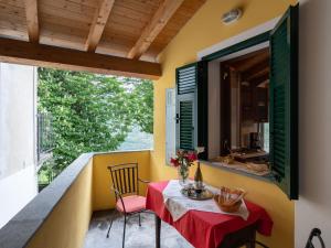a small table with a red table cloth on a balcony at Holiday Home Ca' da Ciassa - Prima Porta - VLO132 by Interhome in Pantasina