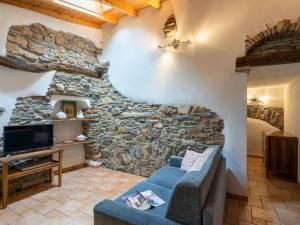 a living room with a stone wall and a couch at Holiday Home Ca' da Ciassa - Prima Porta - VLO132 by Interhome in Pantasina
