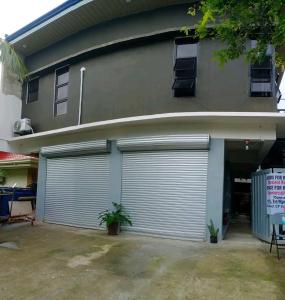 a house with two garage doors on it at Belga Boarding House in Guimaras