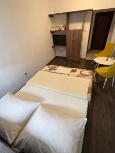 two beds in a room with a table and chairs at Hotel Avanti in Zenica