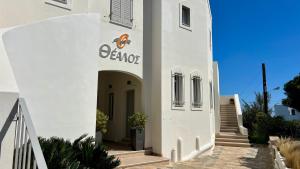 a white building with a sign on it at Thealos in Azolimnos Syros