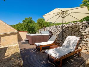 a patio with two chairs and an umbrella at Holiday Home Tomiceva by Interhome in Gornja Klada