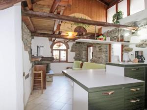 a kitchen with wooden ceilings and a stone fireplace at Holiday Home Caa de Sass by Interhome in Castelveccana