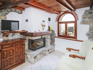 a living room with a fireplace and a tv at Holiday Home Caa de Sass by Interhome in Castelveccana