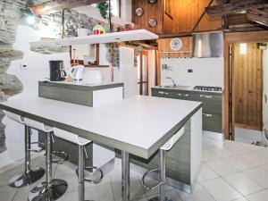 a kitchen with a white counter and stools at Holiday Home Caa de Sass by Interhome in Castelveccana +23 photos