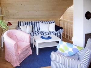 a living room with a couch and two chairs at Apartment Vardeheii by Interhome in Arnefjord
