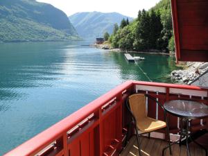 a table and chairs on a balcony overlooking a river at Apartment Vardeheii by Interhome in Arnefjord