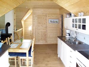 a kitchen with a wooden cabin with a sink and a table at Apartment Vardeheii by Interhome in Arnefjord +11 photos