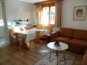 a living room with a table and a couch at Apartment Blumenweg 6 by Interhome in Engelberg