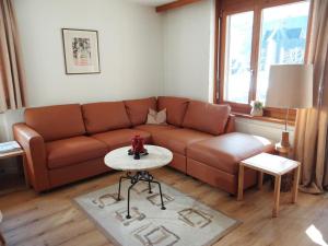 a living room with a brown couch and a table at Apartment Blumenweg 6 by Interhome in Engelberg