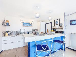 a kitchen with blue and white counters and two stools at Holiday Home TY Greg by Interhome in Crozon +27 photos