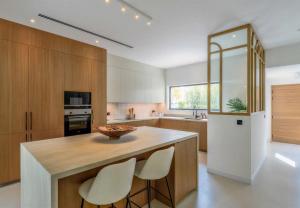 a kitchen with a island with two white chairs at Villa Mansour in Abu Dhabi