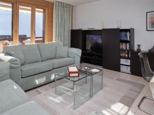 a living room with a couch and a tv at Apartment Bella Vista Apt- No- 09 by Interhome in Wengen