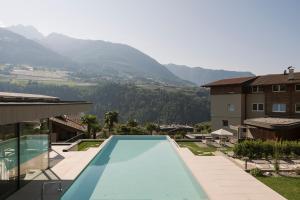 a swimming pool with a view of a mountain at Hotel Zirmerhof & Residence in Rifiano