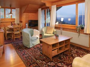 a living room with a table and chairs at Apartment Plein Soleil by Interhome in Wengen +26 photos