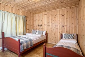 two beds in a room with wooden walls at Rundetjødn 20 in Hol