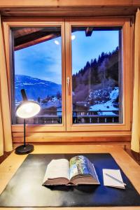 a book laying on a rug in front of a window at Apartment Chalet mit Bergsicht by Interhome in Laax