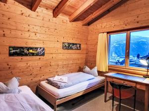 a bedroom with a bed and a desk and a window at Apartment Chalet mit Bergsicht by Interhome in Laax