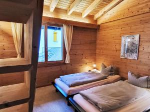 a bedroom with two beds in a wooden cabin at Apartment Chalet mit Bergsicht by Interhome in Laax