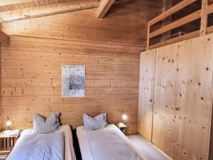 a bedroom with two beds in a wooden wall at Apartment Chalet mit Bergsicht by Interhome in Laax