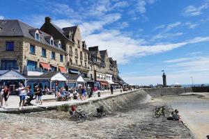 a group of people walking on the beach near the ocean at Camping Bel Air - Cancale in Cancale