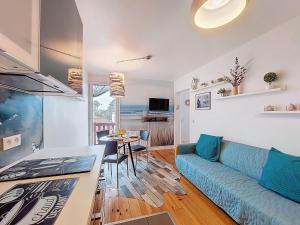 a living room with a blue couch and a table at Apartment la Pergola-2 by Interhome in Soorts-Hossegor