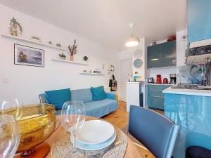 a living room with a blue couch and a table with wine glasses at Apartment la Pergola-2 by Interhome in Soorts-Hossegor