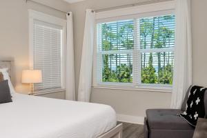 a bedroom with a bed and a window and a chair at Just Beach Baby! by Pristine Property Vacation Rentals in Cape San Blas +60 photos