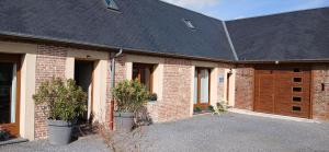 a brick building with two potted plants in front of it at la chambrée in Leschelles