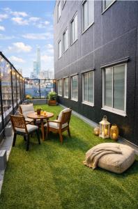 a rooftop patio with grass and a table and chairs at 心斎橋難波関空直通Nambaminami Shin-Imamiya Ambers Hostel in Osaka