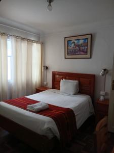 a bedroom with a large bed with a red blanket at Dannas Inn in San Antonio
