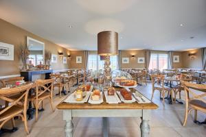 ein Esszimmer mit einem Tisch, auf dem Essen steht in der Unterkunft Les Villas d'Arromanches, Teritoria in Arromanches-les-Bains