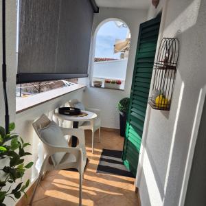 a small balcony with a table and chairs and a window at Roko Apartments in Biograd na Moru