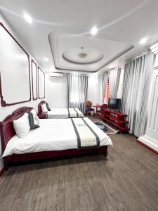 a bedroom with two beds and a television in it at Cao Ánh Hotel in Minh Hóa