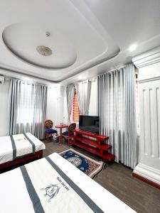a hotel room with two beds and a television at Cao Ánh Hotel in Minh Hóa