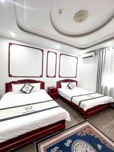 a bedroom with two beds and a ceiling at Cao Ánh Hotel in Minh Hóa